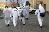 Menschengruppe in weißen Overalls auf den Weg zu einer Veranstaltung